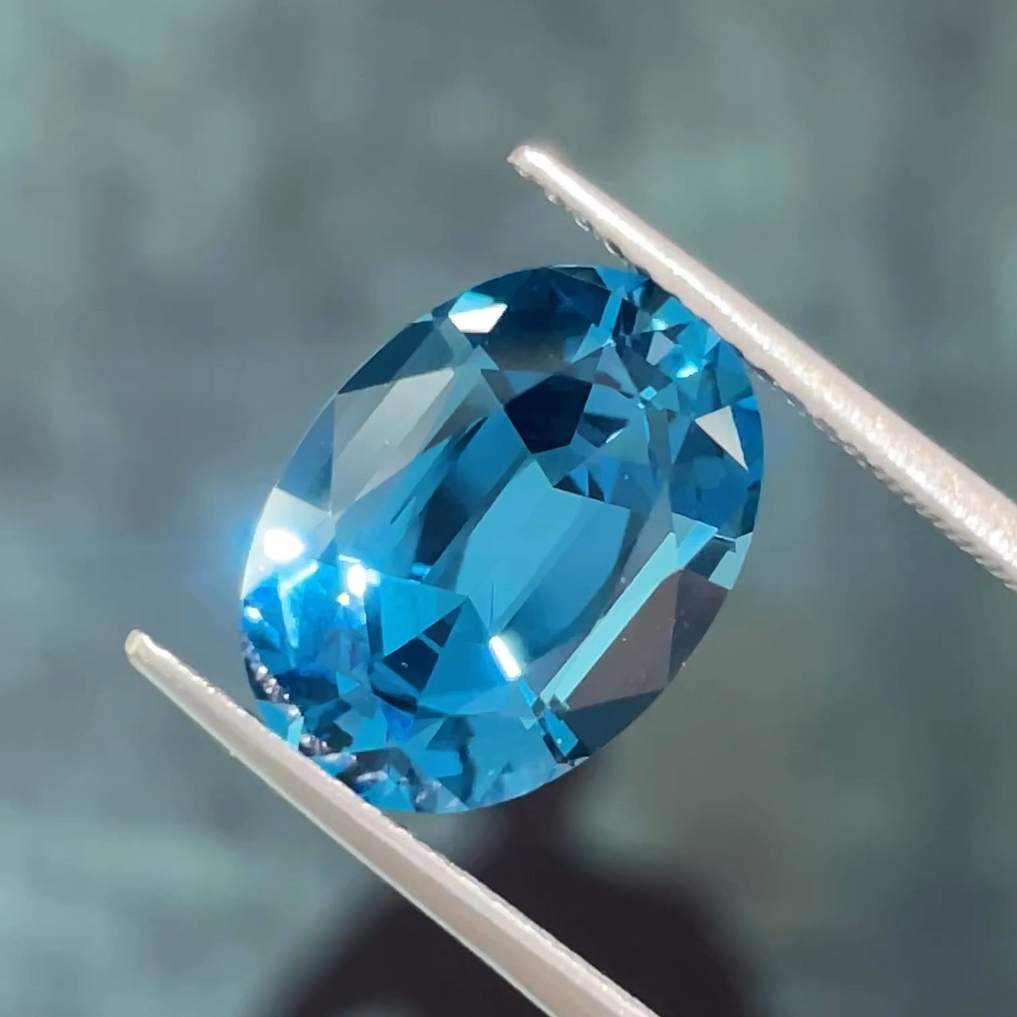 6.22 ct London Blue Topaz with Swiss Blue undertones, face-up view, bluish background