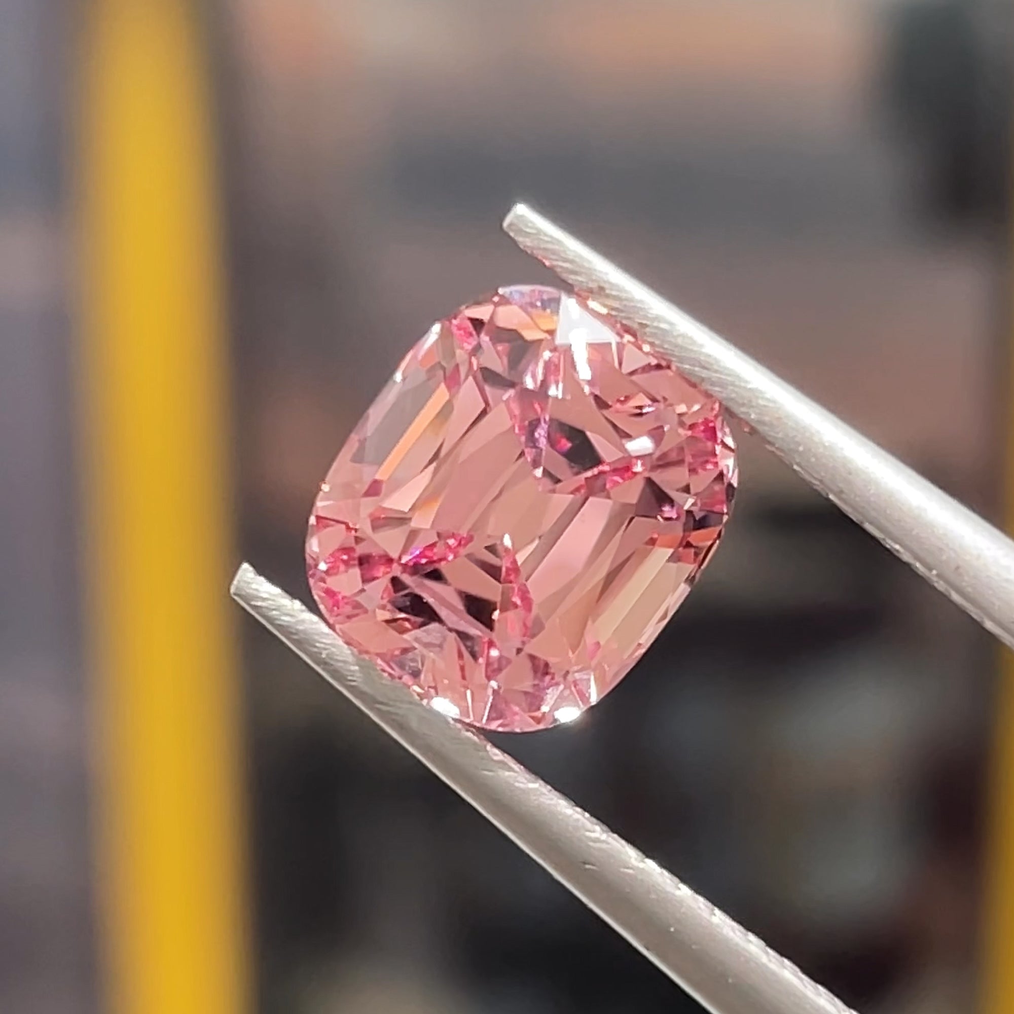 Precision cut 2.72 carat Malaya Mahenge Garnet from Tanzania, Tweezers view, direct light