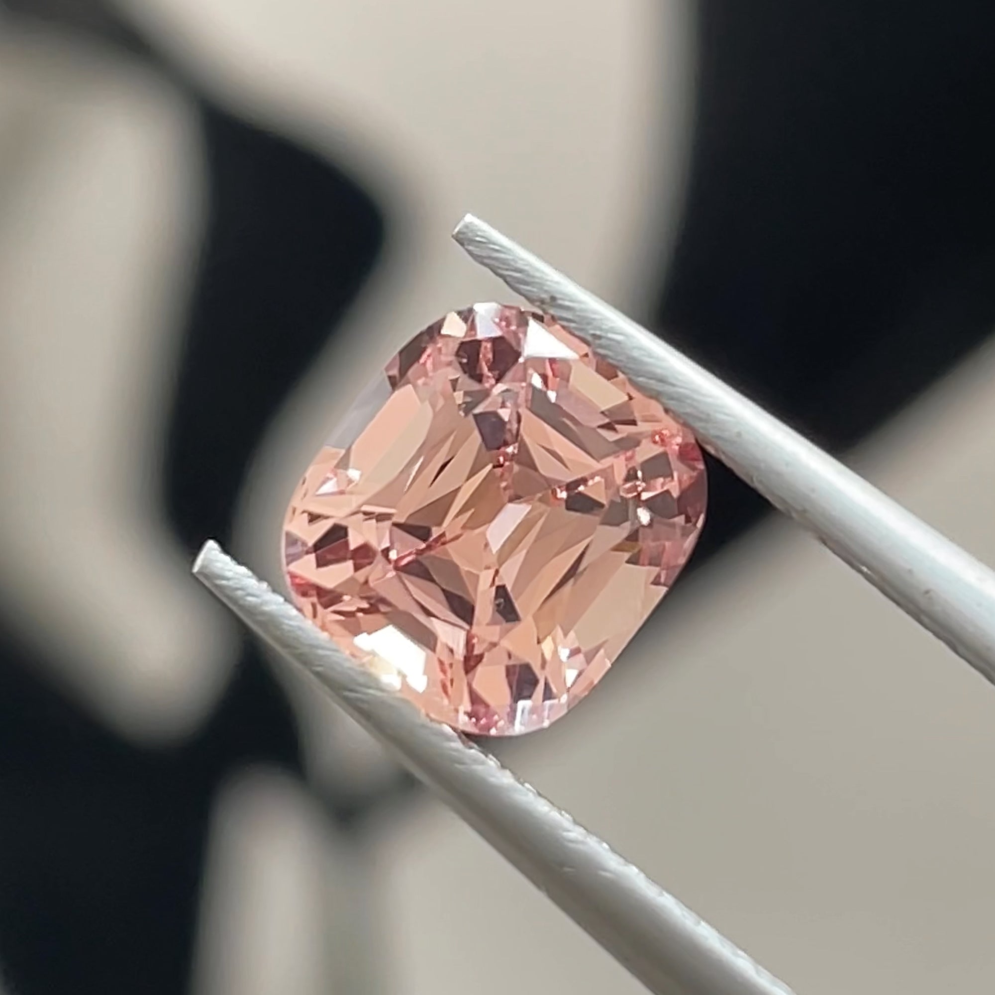 1.82 ct Precision cut Peachy-Pink Mahenge Garnet from Tanzania, cushion shape, tweezers view, black & white background