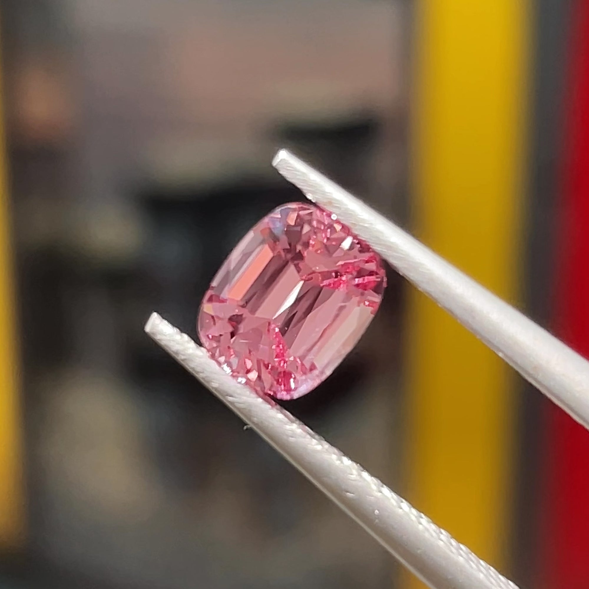 Precision Cut Rose Pink Spinel from Vietnam under direct light, tweezers view