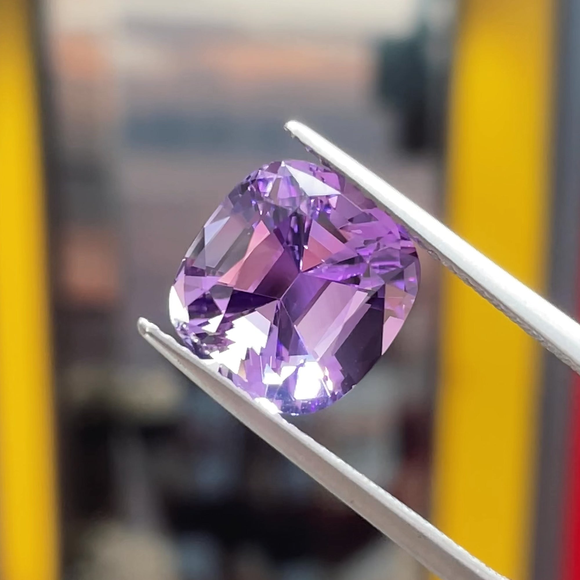 Precision cut 3.92 ct Amethyst cushion from Brazil, tweezers view