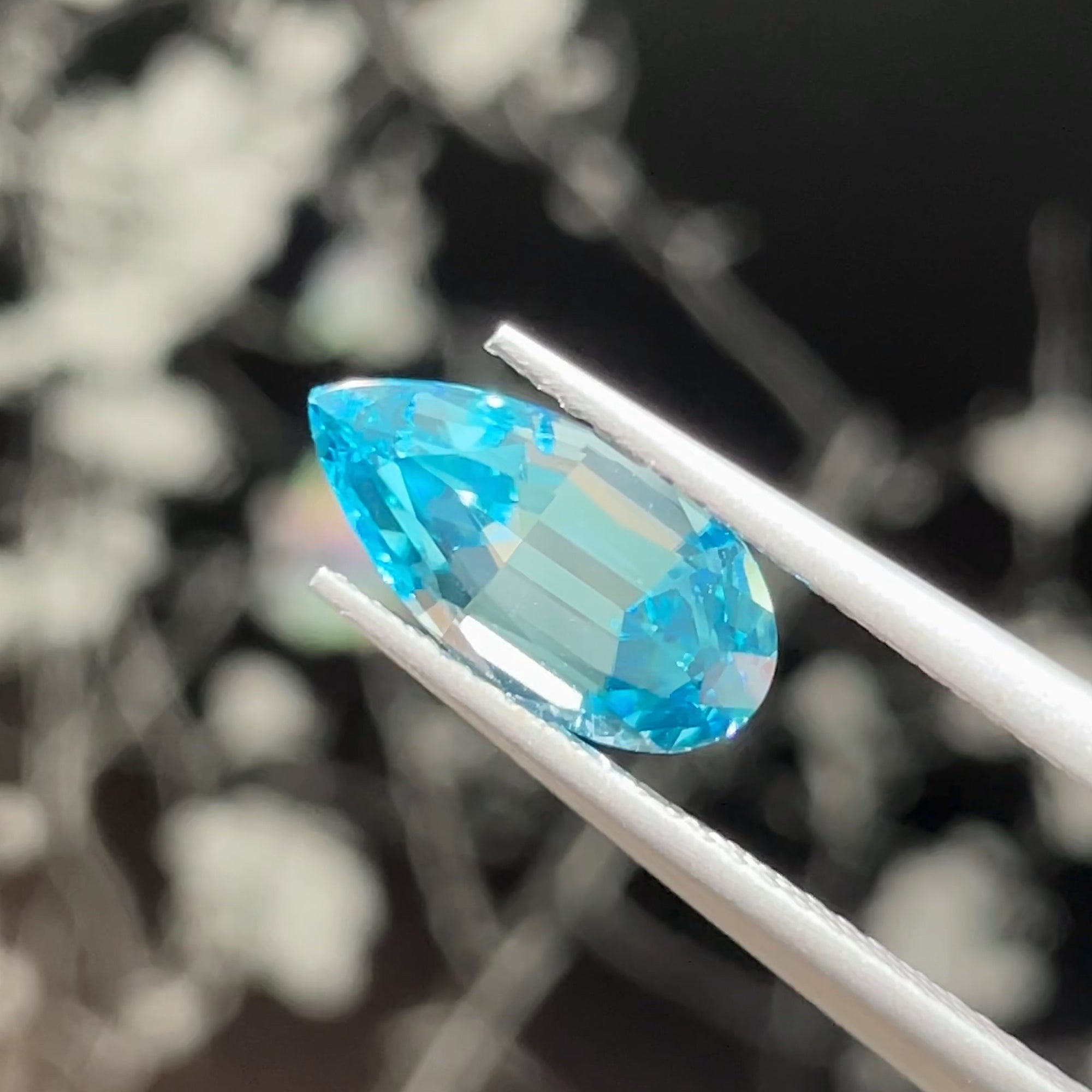 2.76 ct Blue Zircon from Cambodia, precision cut, tweezers view, black background