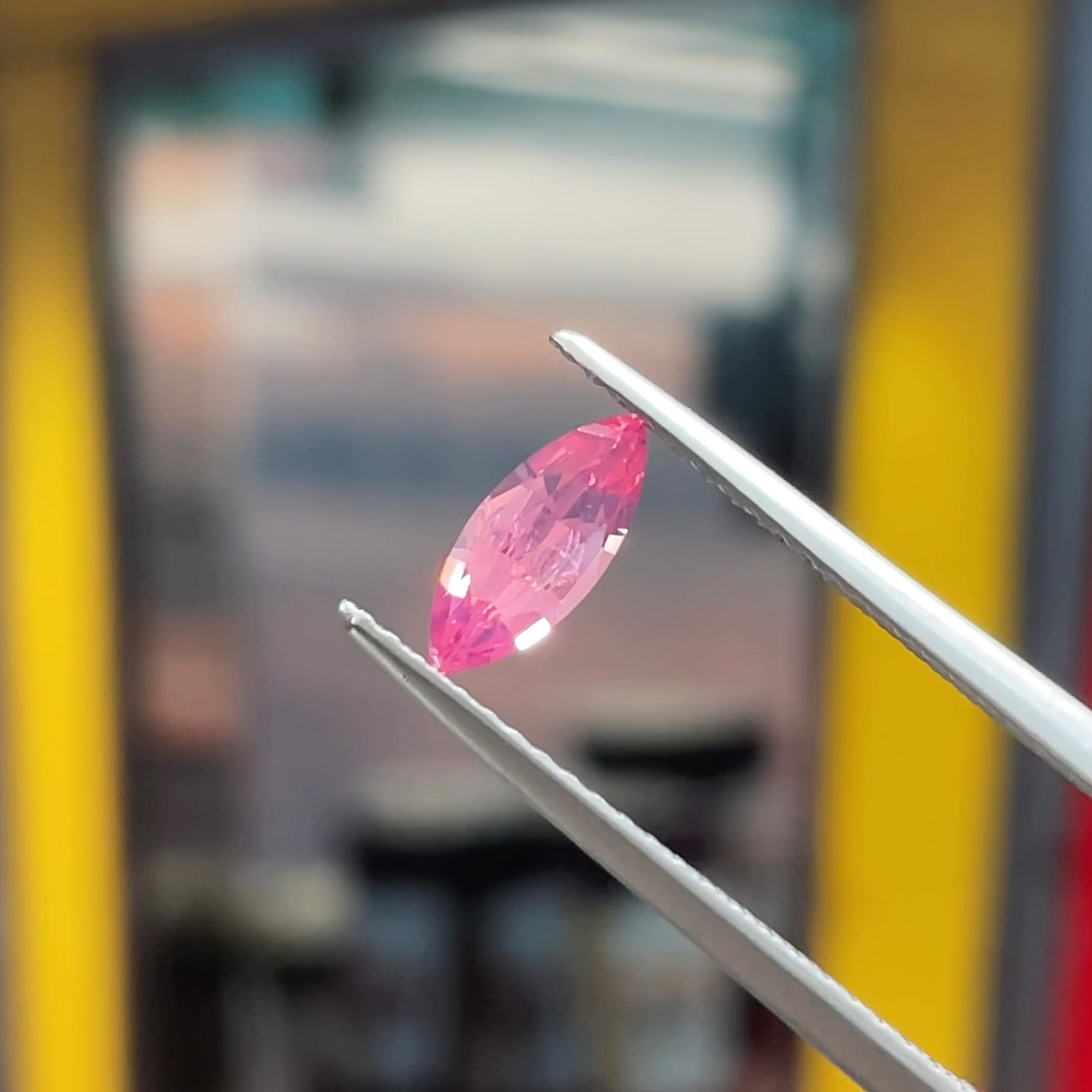 0.41 ct Hot Pink Mahenge Spinel Marquise, precision cut, tweezers view, neutral background
