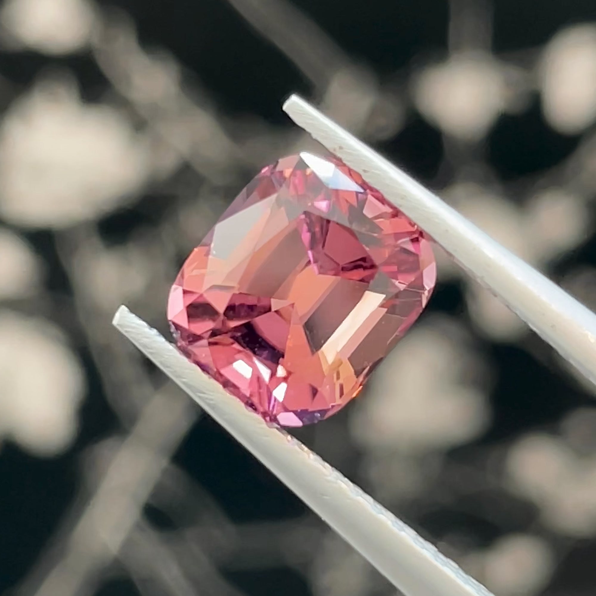 Precision Cut Magenta Pink Tourmaline from Congo, tweezers view, black background