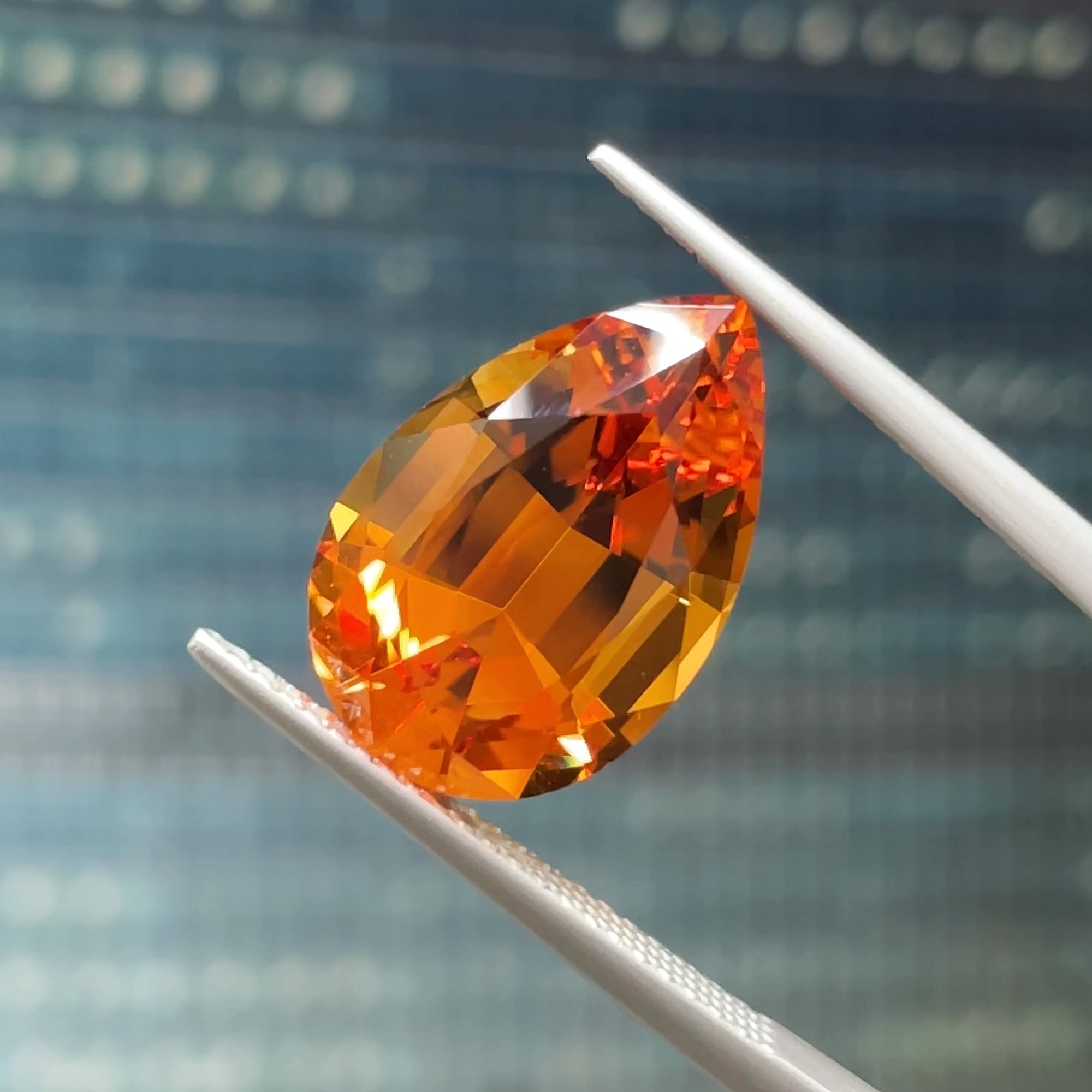 6.80 ct Santa Ana Madeira Citrine, precision cut, tweezers view, blue background